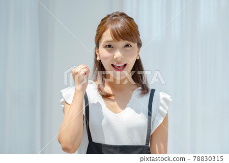 一個穿著夏裝的年輕女子在白牆前接受陽光 78830315