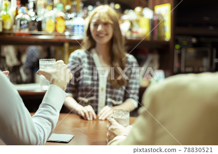 Young woman serving liquor at the counter bar Young woman serving liquor at the counter bar 78830521