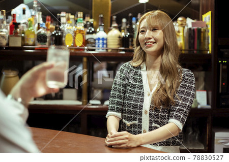 在櫃檯酒吧供應酒的年輕女子 78830527