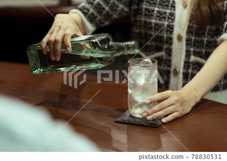 Young woman serving liquor at the counter bar 78830531