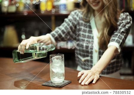 Young woman serving liquor at the counter bar 78830532