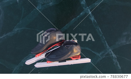 The skates are on the ice. The child train on ice speed skating. The athlete skates in the winter. Children speed skating short long track outdoor. The skates are on the ice. The child train on ice speed skating. The athlete skates in the winter. Children speed skating short long track outdoor. 78830677