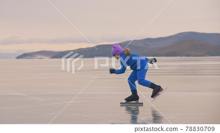 The girl train on ice speed skating. The child skates in the winter in blue sportswear suit, sport glasses. Children speed skating sport. The girl train on ice speed skating. The child skates in the winter in blue sportswear suit, sport glasses. Children speed skating sport. 78830709