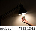 man is changing the reading lamp 78831342