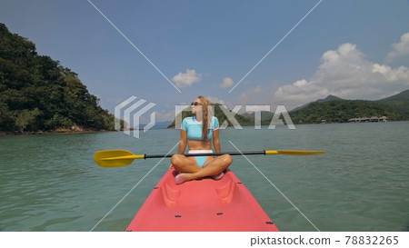 Sportive woman rows pink plastic canoe along sea water. 78832265