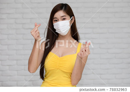 Wellness asian young woman wear face mask and yellow camisole make mini heart for good protection and vaccine happiness and cheerful,New normal due virus pandemic concept Wellness asian young woman wear face mask and yellow camisole make mini heart for good protection and vaccine happiness and cheerful,New normal due virus pandemic concept 78832963