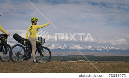 The man and woman travel on mixed terrain cycle touring with bikepacking. The love couple journey with tent in with bicycle bags. Stylish sportswear. 78833073