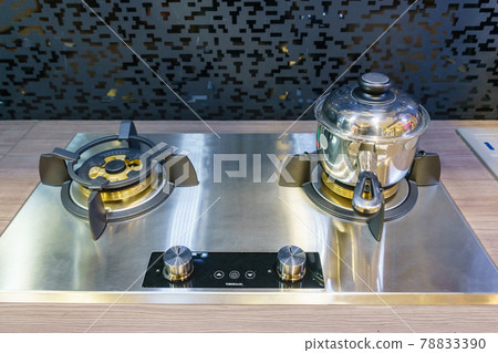 Modern kitchen furniture with contemporary kitchenware like hood, black induction stove and oven in house. 78833390