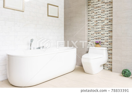 Modern bathroom interior with minimalistic shower and lighting, white toilet, sink and bathtub Modern bathroom interior with minimalistic shower and lighting, white toilet, sink and bathtub 78833391