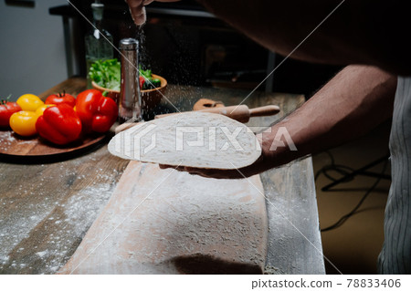 men's hands hold a thin flatbread. Cooking pizza, noodles or pitta at home men's hands hold a thin flatbread. Cooking pizza, noodles or pitta at home 78833406