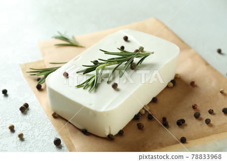 Baking paper with feta, pepper and rosemary on white textured background Baking paper with feta, pepper and rosemary on white textured background 78833968
