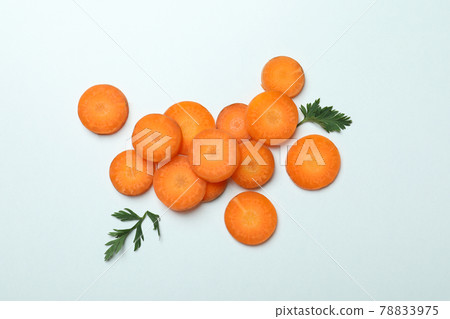 Carrot slices and leaves on white background 78833975