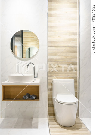 Modern spacious bathroom with bright tiles with toilet and sink. Side view Modern spacious bathroom with bright tiles with toilet and sink. Side view 78834552