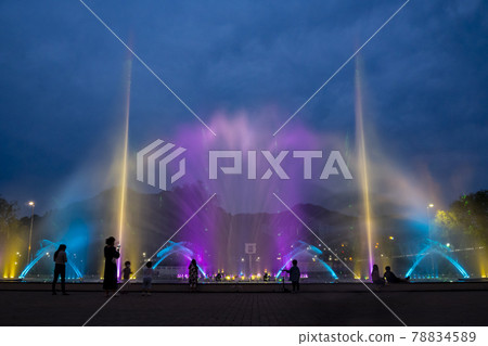 Colorful fountain and laser show against a blue sky 78834589