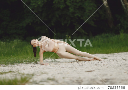 Woman practicing advanced yoga on a summer beach 78835366