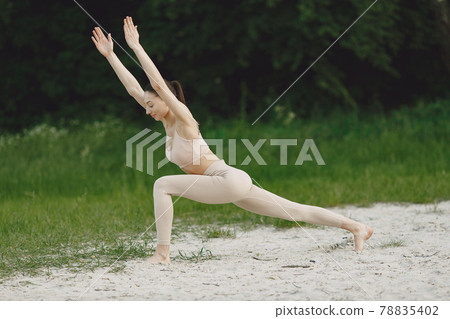 Woman practicing advanced yoga in a beach Woman practicing advanced yoga in a beach 78835402