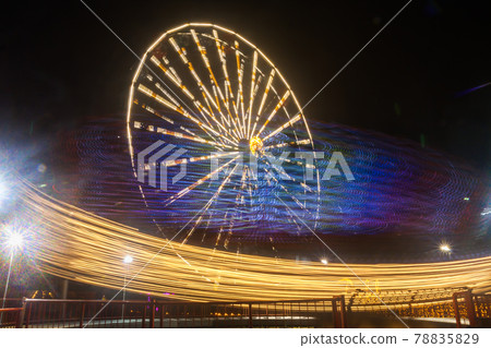 Ferris wheel in motion at the amusement park, night illumination. Long exposure Ferris wheel in motion at the amusement park, night illumination. Long exposure 78835829
