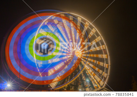 Ferris wheel in motion at the amusement park, night illumination. Long exposure 78835841