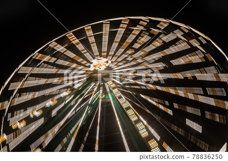 Ferris wheel in motion at the amusement park, night illumination. Long exposure 78836250