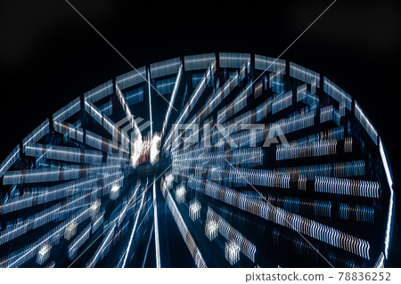 Ferris wheel in motion at the amusement park, night illumination. Long exposure Ferris wheel in motion at the amusement park, night illumination. Long exposure 78836252
