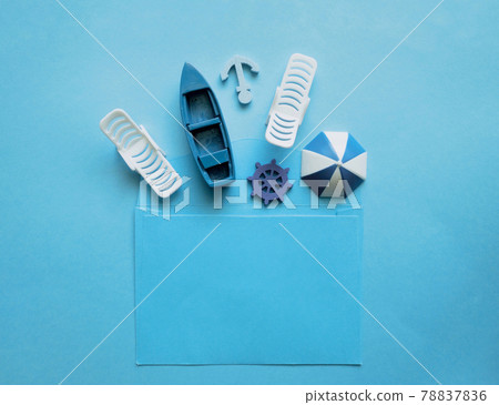 Blue envelope with sun lounger, beach umbrella, boat, anchor, steering wheel inside on a blue background. Blue envelope with sun lounger, beach umbrella, boat, anchor, steering wheel inside on a blue background. 78837836