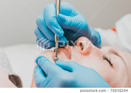 The beautician cleanses the patient's skin with a spoon uno, moisturizing, cleansing and skin care. The beautician cleanses the patient's skin with a spoon uno, moisturizing, cleansing and skin care. 78838204