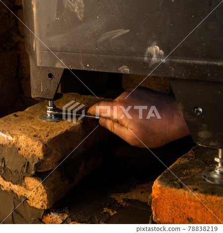 Installing a fireplace with a water furnace in the house, details close up. Installing a fireplace with a water furnace in the house, details close up. 78838219