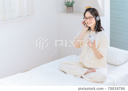 Young woman using a smartphone in bed Young woman using a smartphone in bed 78838786