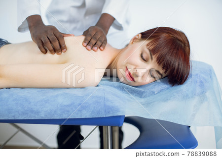 Close up of beautiful young naked european woman getting back massage Close up of beautiful young naked european woman getting back massage 78839088