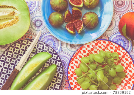 Healthy, fruit breakfast - figs, melon and grapes on colorful plates; summer fruit 78839192