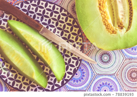 Half and sliced melon on blue colorful background; food background 78839193