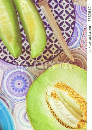 Half and sliced melon on blue colorful background; food background 78839194