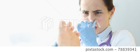 Doctor dermatologist holding patients foot and covering nose with hand Doctor dermatologist holding patients foot and covering nose with hand 78839341