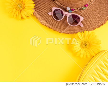 Yellow fashion holiday background with straw hat, sunglasses, handbag and flowers on monochrome Yellow fashion holiday background with straw hat, sunglasses, handbag and flowers on monochrome 78839597