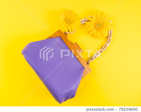 Purple fashion lady handbag with gerbera daisy flowers on yellow background Purple fashion lady handbag with gerbera daisy flowers on yellow background 78839600