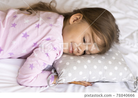 home, comfort, childhood, care, love, sweet dream- little pretty smiling happy authentic toddler sibling kid child girl in pajamas lie rest sleep on bed pillows with closed eyes soft cozy sleepy mood 78840666