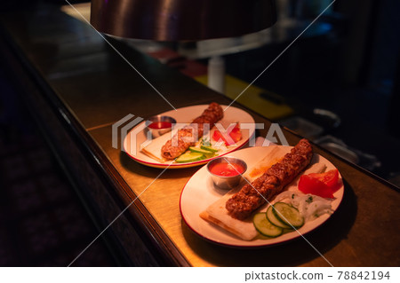 Delicious seekh kabab served in plate at table. 78842194