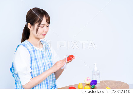 Nursery woman disinfecting toys 78842348