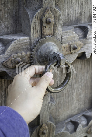 Old open wooden door with carved pattern 78844924