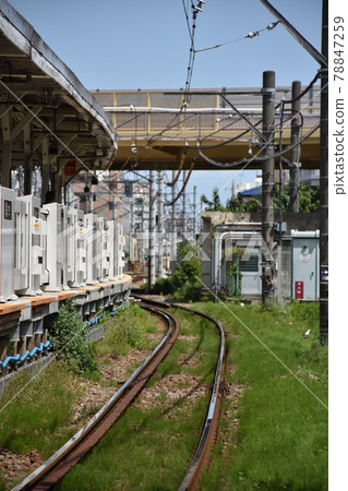 陽光明媚的日子，從當地線路的鐵路道口取下的房屋和鐵軌 78847259