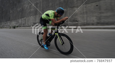 triathlon athlete riding a bike on morning training triathlon athlete riding a bike on morning training 78847937