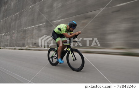 triathlon athlete riding a bike on morning training triathlon athlete riding a bike on morning training 78848240