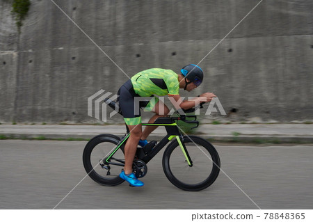 triathlon athlete riding a bike on morning training triathlon athlete riding a bike on morning training 78848365