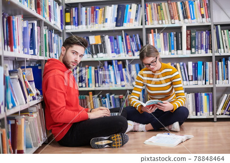 the students uses a notebook, laptop and a school library 78848464