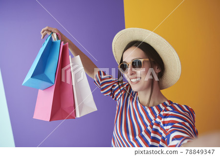 Young woman with shopping bags on colorful background Young woman with shopping bags on colorful background 78849347