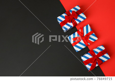 Blue and white stripe gift boxes with red bows on classic red background in the national colors of America, Russia, France or England, the concept of Independence Day, a national holiday, sale Blue and white stripe gift boxes with red bows on classic red background in the national colors of America, Russia, France or England, the concept of Independence Day, a national holiday, sale 78849715