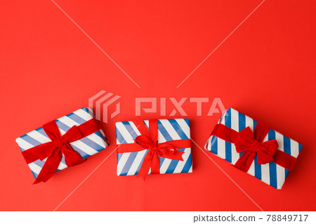 4th of July American Independence Day. Happy Independence Day. White blue stripe gift boxes with red bow on red background. Flat lay, top view, copy space, banner, copy space, sale, Christmas 4th of July American Independence Day. Happy Independence Day. White blue stripe gift boxes with red bow on red background. Flat lay, top view, copy space, banner, copy space, sale, Christmas 78849717