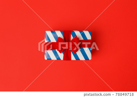 Blue white stripe gift box with red bows on red background in national colors of USA, Russia, France or England, the concept of Independence Day, a national holiday, copy space, sale, Christmas theme Blue white stripe gift box with red bows on red background in national colors of USA, Russia, France or England, the concept of Independence Day, a national holiday, copy space, sale, Christmas theme 78849718