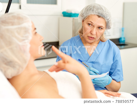 Skillful cosmetologist consulting young woman in medical esthetic office 78850577