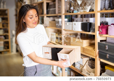 Woman consumer choosing wooden box in furniture shop Woman consumer choosing wooden box in furniture shop 78850973